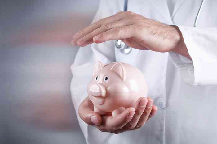 Arzt hält Hand über Sparschwein - © andranik123 - stock.adobe.com
