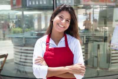 Junge Kellnerin vor dem Restaurant